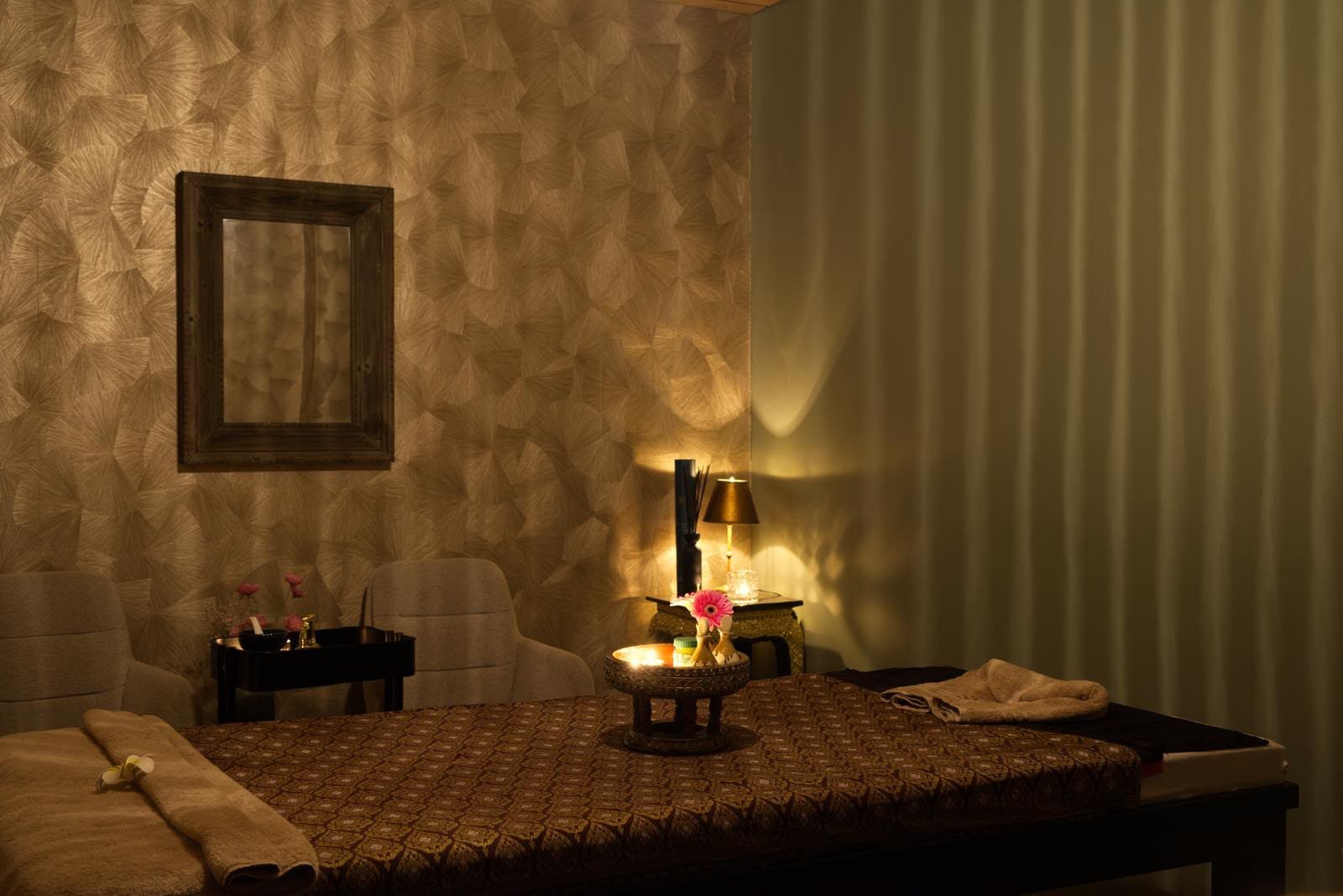 Sfeervolle enkele behandelkamer met warme verlichting en Thaise decoratie bij Sukhumvit Naarden