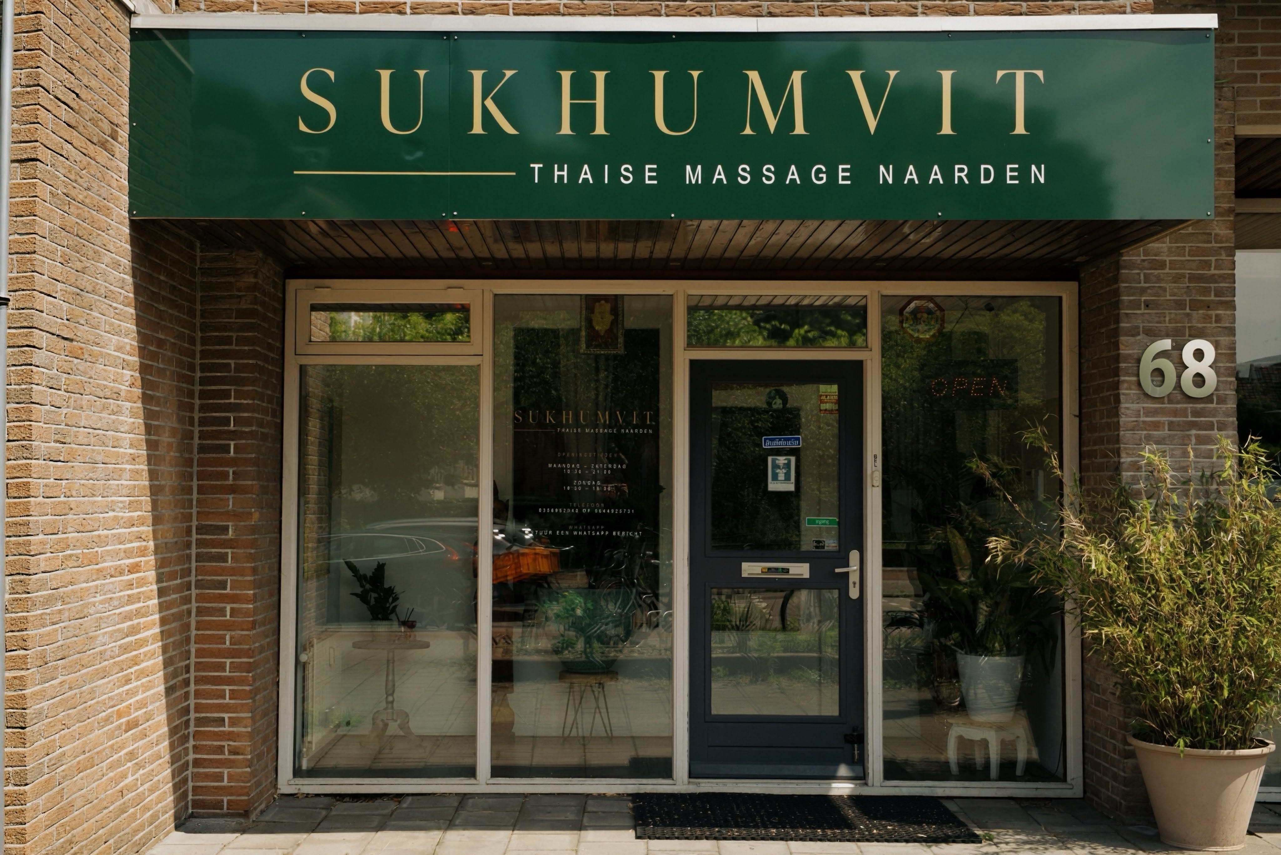 Gevel van Sukhumvit Thaise Massage aan de straat in Naarden met groene luifel en het SUKHUMVIT logo