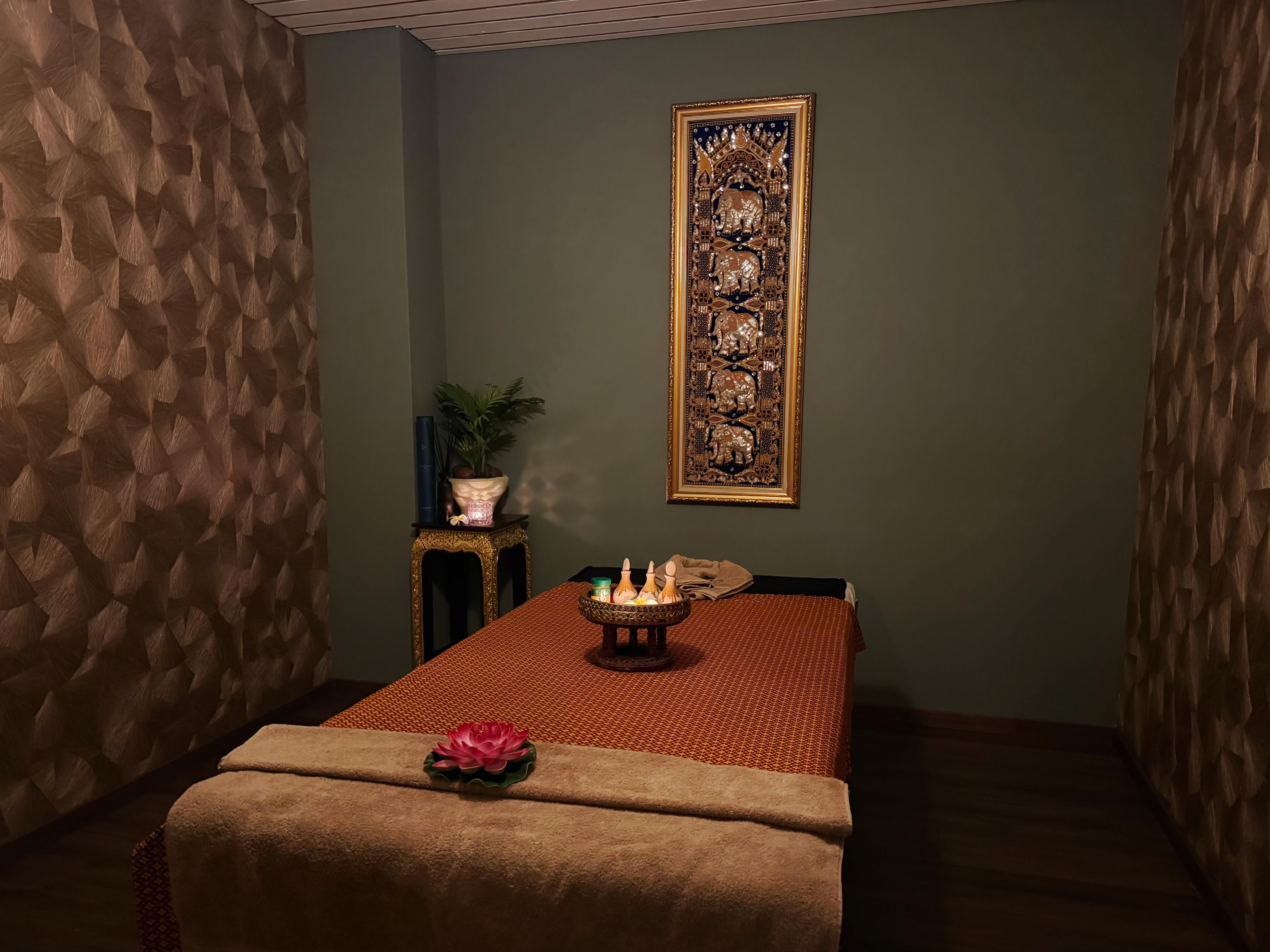 Sfeervolle enkele massagekamer met Thaise kunst en warme verlichting bij Sukhumvit Naarden